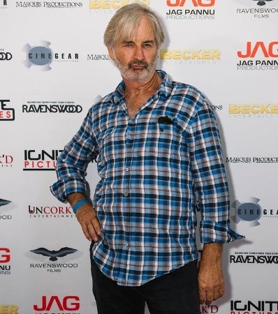 Picture of John Jarratt in a blue shirt posing for photoshoot in promotion event.